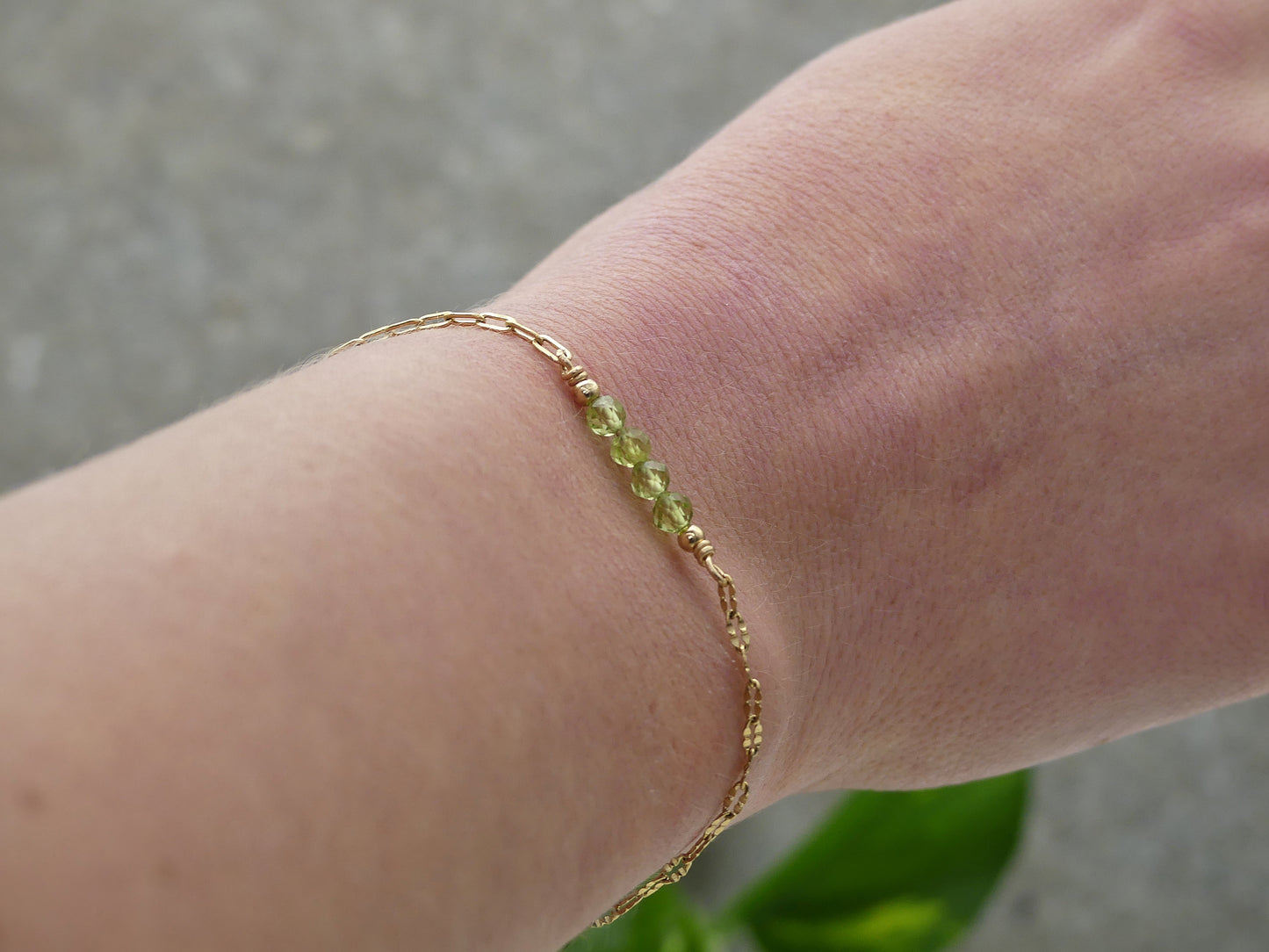 minimalistische paperclip armband goud geplatteerd met groene peridot edelsteentjes en gouden bolletjes