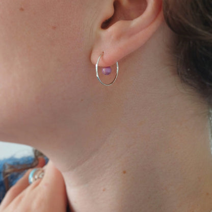 vrouw en profil met zilveren creool van en in het midden een lilia edelsteentje. 